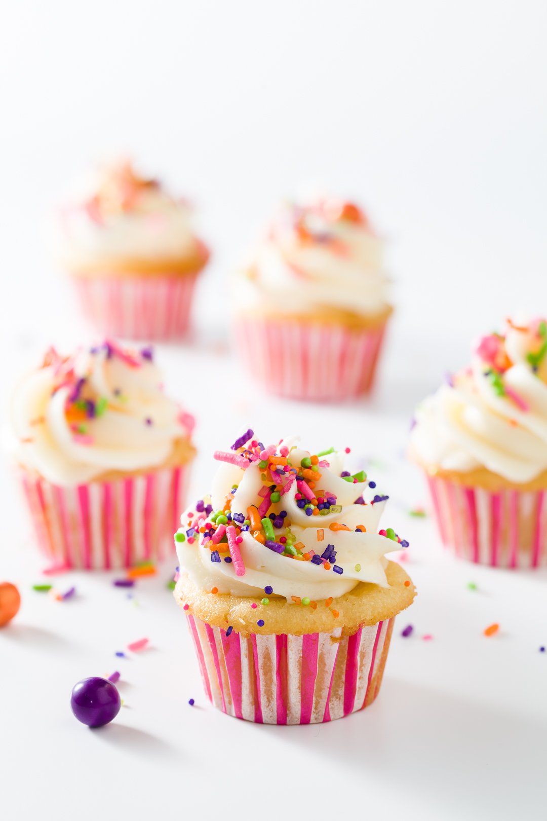 A group of mini cupcakes in pink and white liners