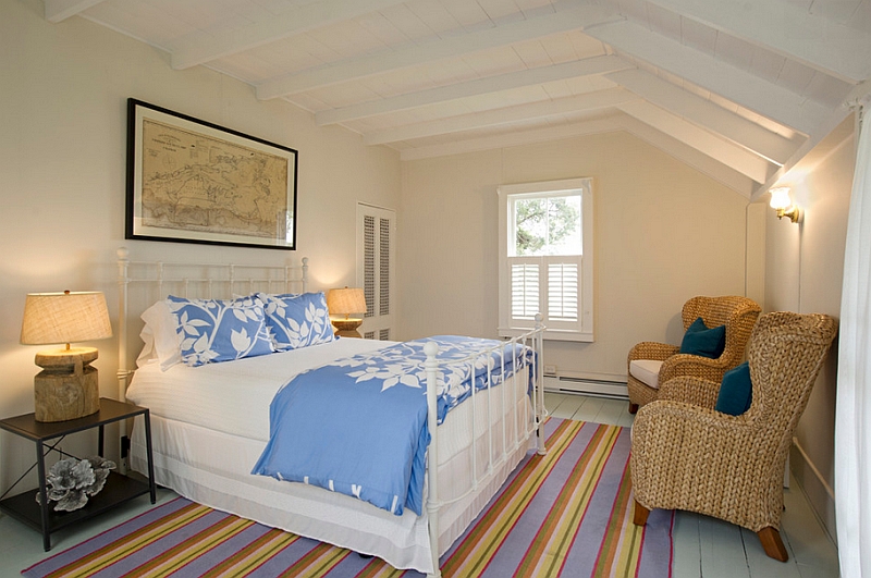 Beach style bedroom with low sloped ceiling and unique decor.