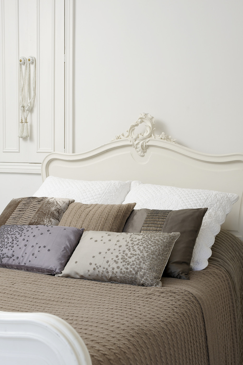 Taupe bedding offsets white walls