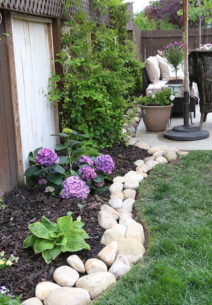 stone border around garden edge grass trees patio