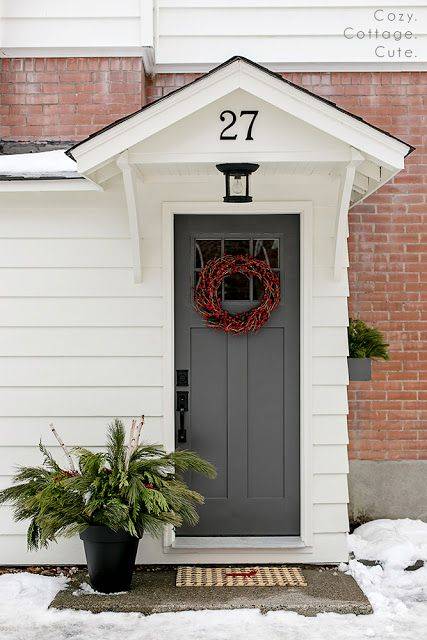 A grey door with a wreath on it.