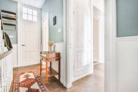 Light blue corridor with a wooden chest of drawers on high legs