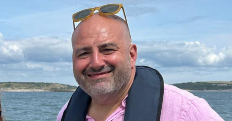 Wynne Evans smiling in a life vest