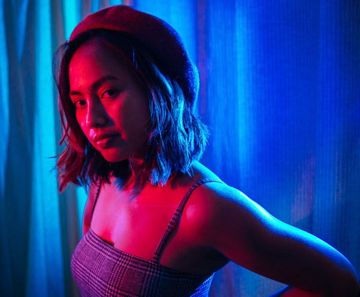 A dramatic blue and pink colored portrait of a female model using lighting gels