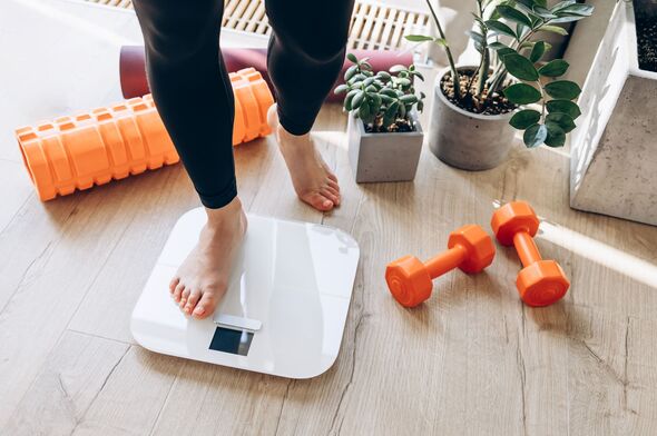 Woman steps on a weighing scale