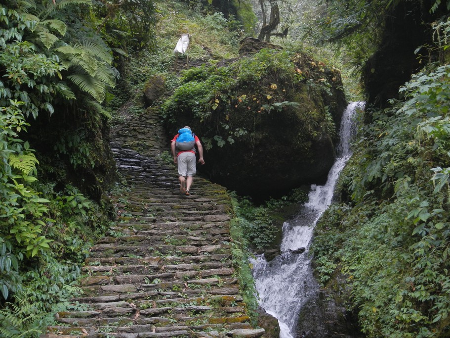 Climbing stone steps past a waterfall