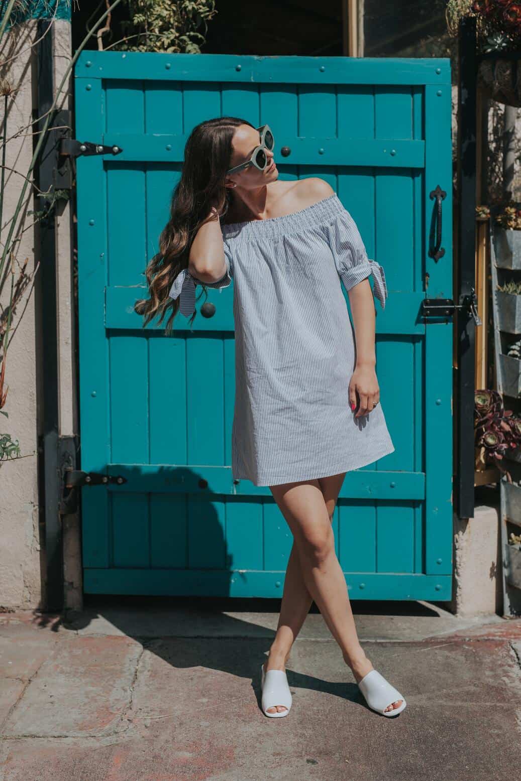 woman in blue dress posing in front of blue door