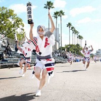 桟敷席や踊り手たちの間隔を空けて行われた阿波踊りの実証イベントで、フェースシールドを着けて踊る踊り手たち＝徳島市で２１日、山崎一輝撮影