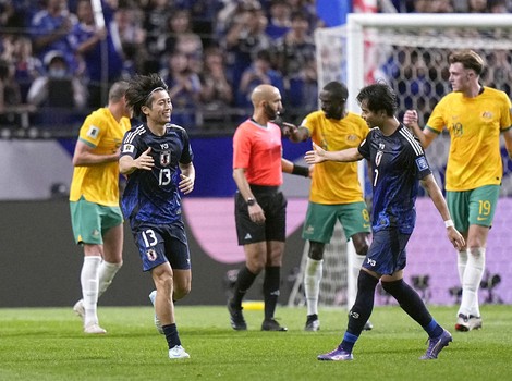 Japan's Keito Nakamura (13) runs over to teammate Kaoru Mitoma (7) to celebrate after an own goal from Australia gifts the Samurai Blue an equalizer in the second half of a 2026 football World Cup Asian qualifier at Saitama Stadium near Tokyo on Oct. 15, 2024. (Kyodo)