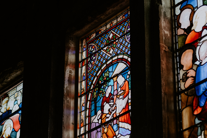 Colorful stained glass windows in dark chapel from the inside