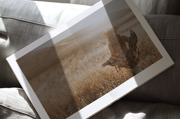 Open landscape photo book with newlywed couple walking together on beach on the pages