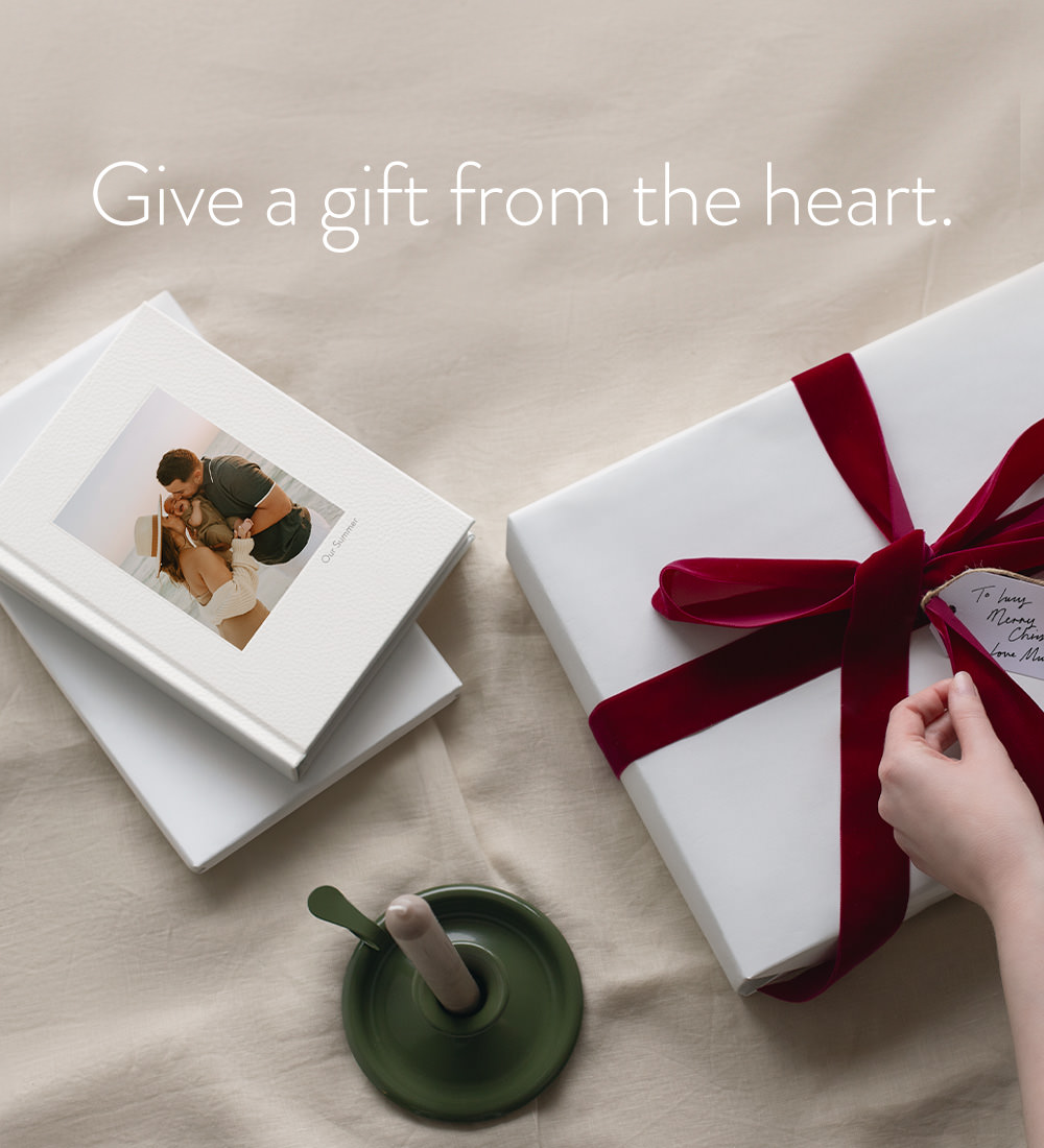 Give a gift from the heart. Premium Portrait Photo Album next to a white paper wrapped gift