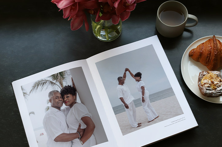 Open wedding photo album of couple dancing on beach