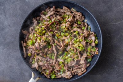 Beef, peppers and onion in a pan.