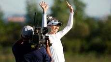 Nelly Korda celebrates winning a tournament with a camera man up close