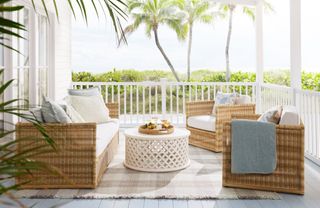 A wicker outdoor sofa set on a porch