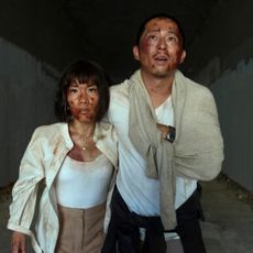 Ali Wong as Amy and Steven Yeun as Danny, injured and leaning on each other while walking out of a tunnel, in episode 110 of Beef.