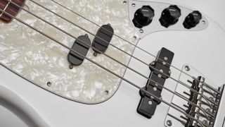 Close up of light blue Fender Mustang, with black split mustang pickup and jazz bass pickup