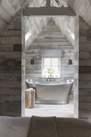 silver bath in wood clad bathroom