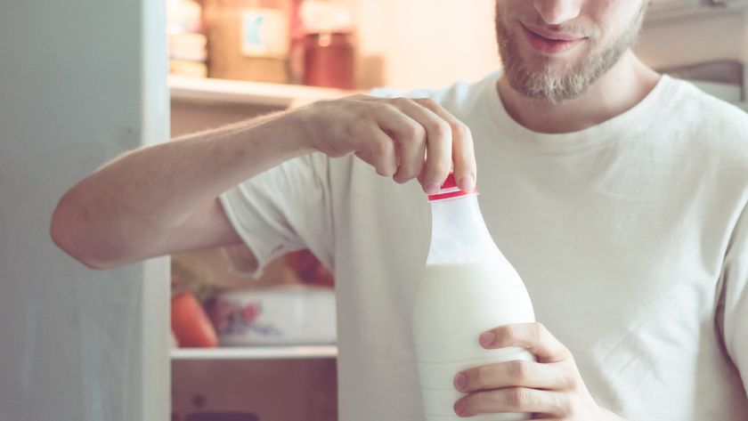 a man drinks milk from his fridge