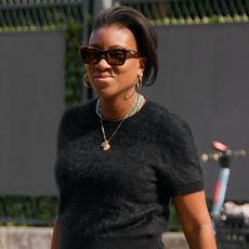 nikki ogunnaike wearing. a black t-shirt, sunglasses, and gold jewelry 