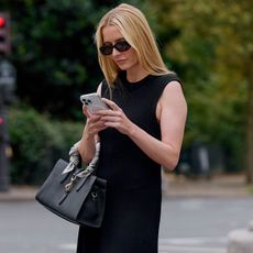 Woman in black dress looking at phone