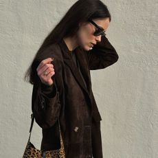 Annabel wears a brown suede trench coat and leopard print YSL bag.