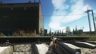 Aiming an assault rifle in a dilapidated railroad area