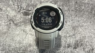 En ljusgrå Garmin Instinct 2 ligger med urtavlan vänd uppåt