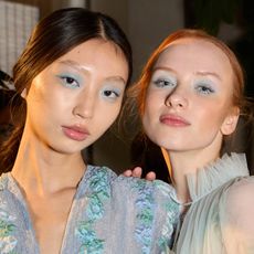 two models wearing blue eyeshadow with soap brows