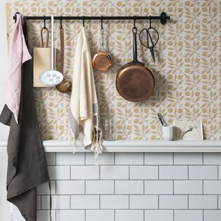 Kitchen with floral wallpaper and hanging utensils