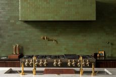 An olive green kitchen with tiled range hood