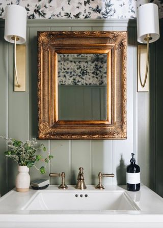 Farmhouse bathroom sink with sage shiplap walls and vintage gold-framed mirror