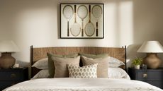 a rattan bed with tennis racquet art above the bed