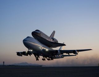 Space shuttle Discovery and its modified 747 carrier aircraft lift off from Edwards Air Force Base early in the morning of Sept. 20, 2009 on the first leg of its ferry flight back to the Kennedy Space Center in Florida.