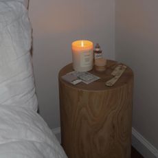 Candle burning on a bedside table