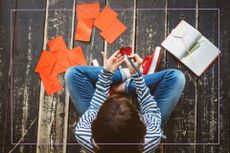 child sat cross legged writing valentine's cards