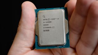 A masculine hand holding an Intel Core i9-14900K