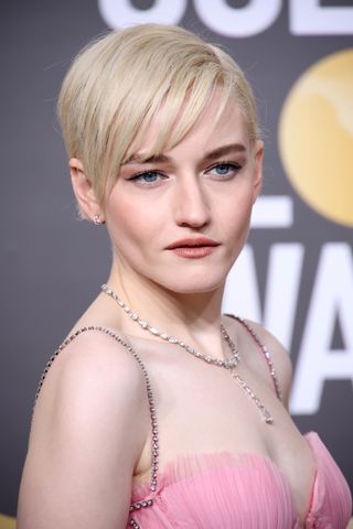 julia garner with her hair cut into a pixie cut.