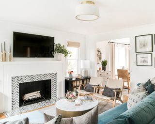 Patterned inlay on fireplace surround with white decorative logs in fireplace.