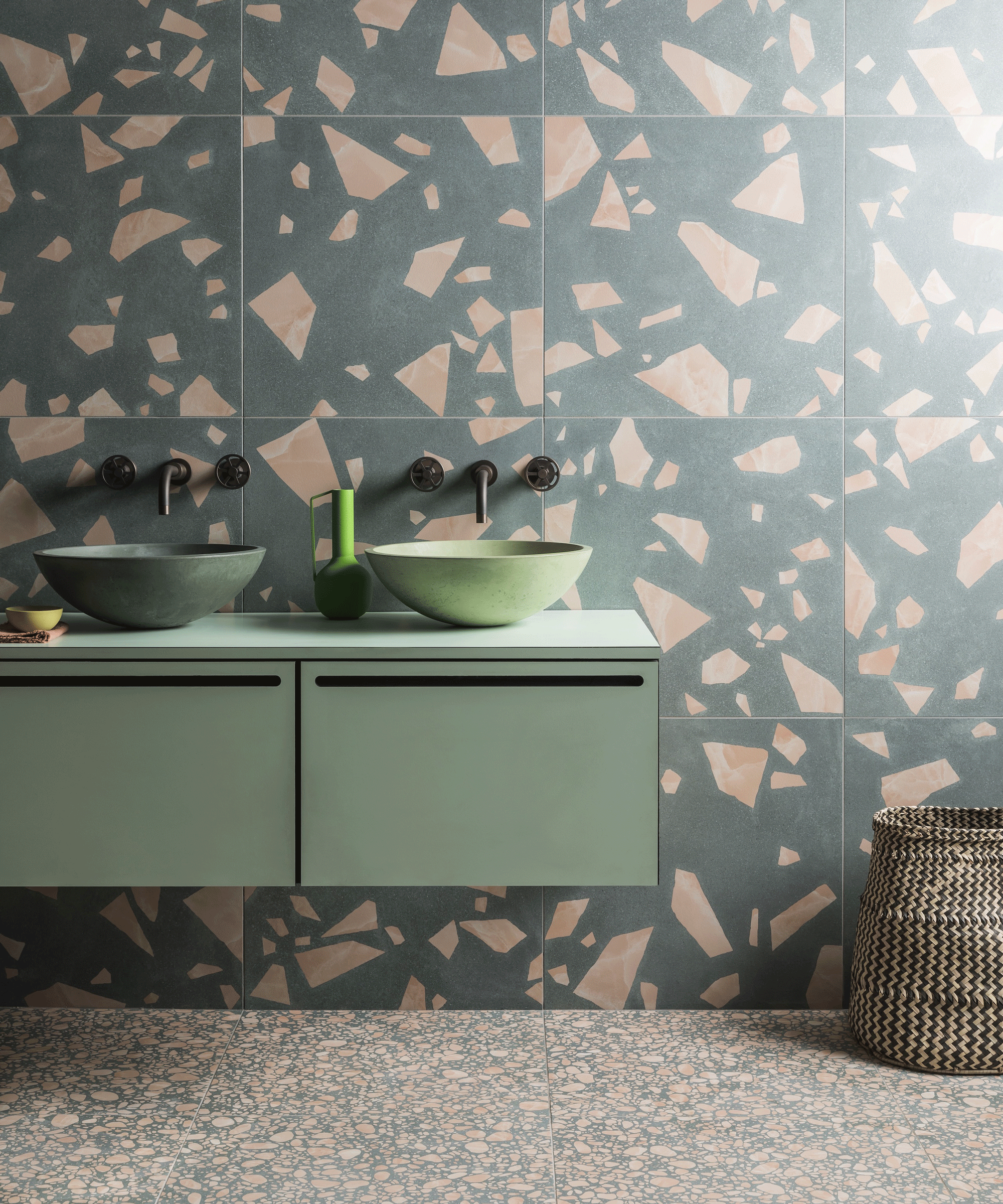 bathroom with terrazzo wall and green vanity with double sinks