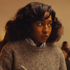 ayo edebiri wears a grey sweater and looks nervous at a dinner party in a still from opus