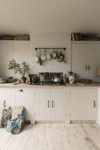 white standard tongue and grove shaker kitchen with pots hung above the stove