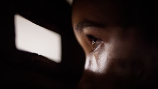 A person spying through a gap of light