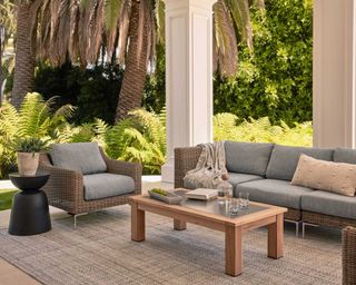 Outer wicker outdoor furniture on a white walled patio