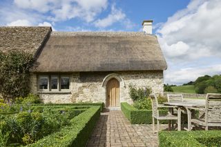 bespoke cottage door crafted by with thatched roof and stone cottage