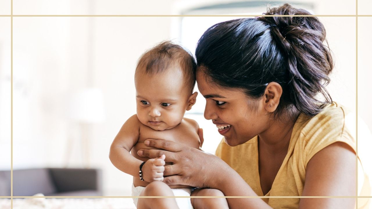 Woman with dark hair sat with baby