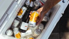 Best cool box for camping: Person lifting a can out of a Yeti cool box