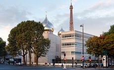 A street view of a modern Russian Orthodox Spiritual and Cultural Centre featuring three metallic domes with crosses on top. 