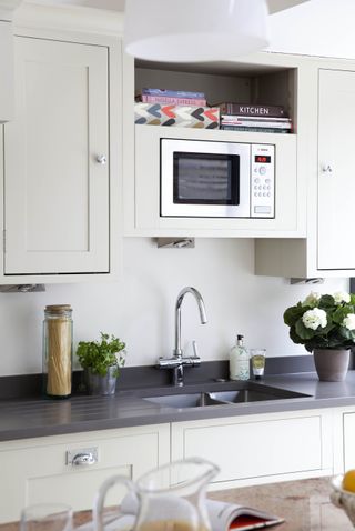 Kitchen with neutral cabinets, dark countertop and microwave